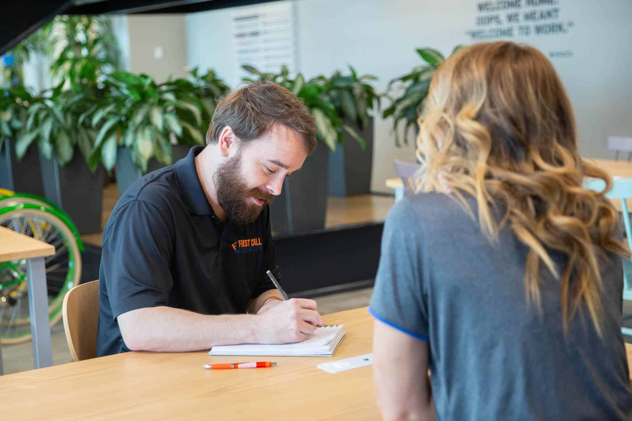 First Call employee, Ryan, taking notes during a team meeting.