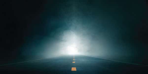 iStock-1411436221-bright-light-on-dark-lit-road